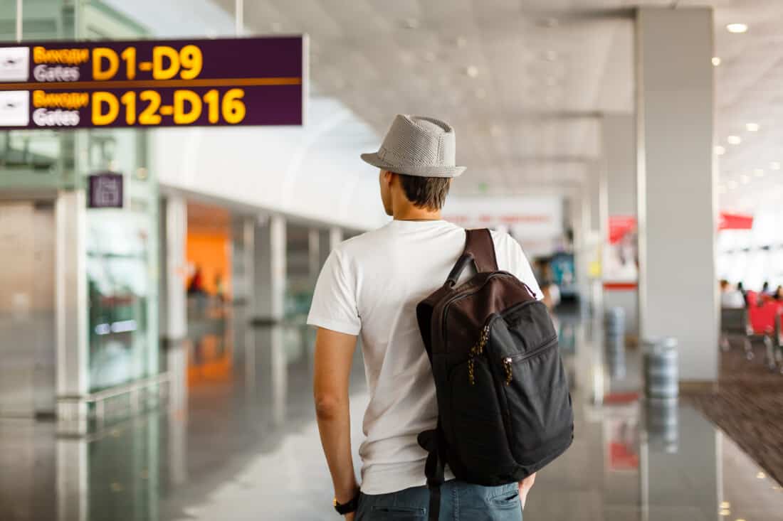 Traveler man wearing hat with backpack in airport terminal